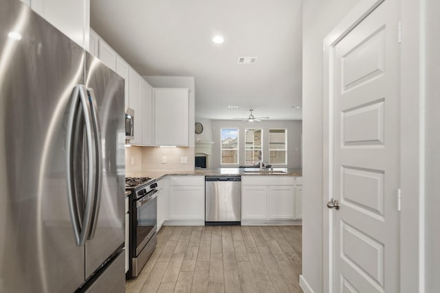 kitchen featuring visible vents, tasteful backsplash, appliances with stainless steel finishes, and white cabinetry