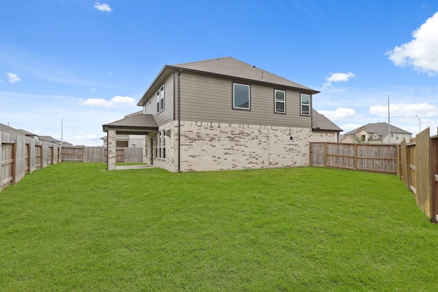 back of property featuring a lawn, roof with shingles, and a fenced backyard