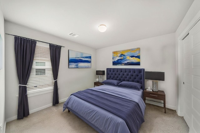 bedroom featuring a closet, baseboards, and light colored carpet