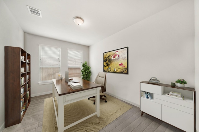 office area featuring visible vents, baseboards, and light wood-style floors