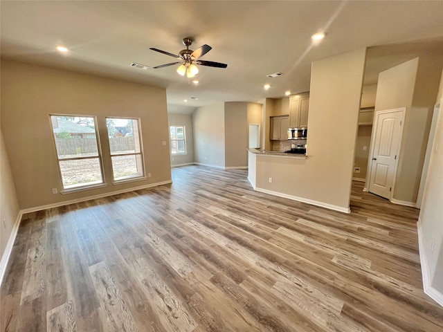 unfurnished living room featuring recessed lighting, baseboards, light wood-style floors, and a ceiling fan