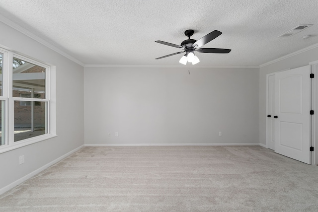 unfurnished room with baseboards, visible vents, ceiling fan, light carpet, and crown molding