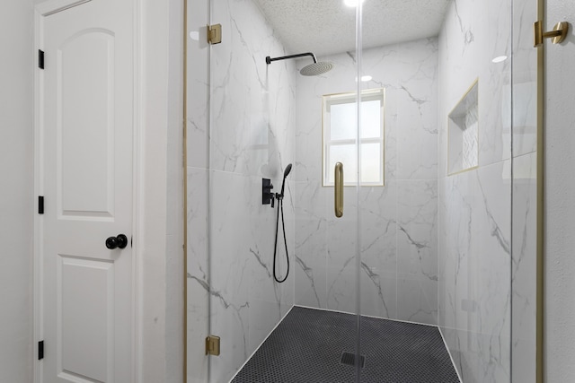 full bathroom featuring a marble finish shower and a textured ceiling