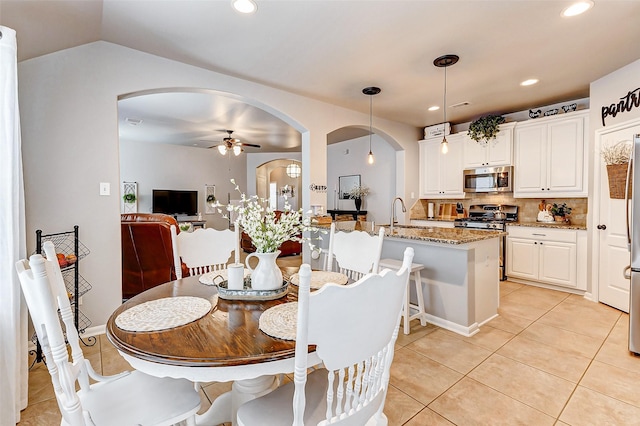 dining area featuring arched walkways, light tile patterned floors, recessed lighting, and ceiling fan