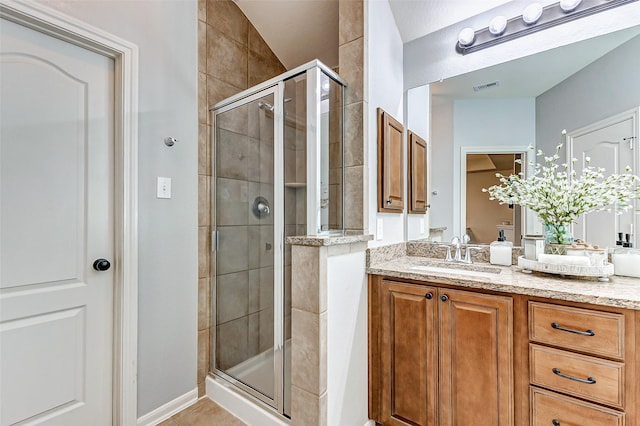 bathroom featuring tile patterned floors, visible vents, a stall shower, and vanity