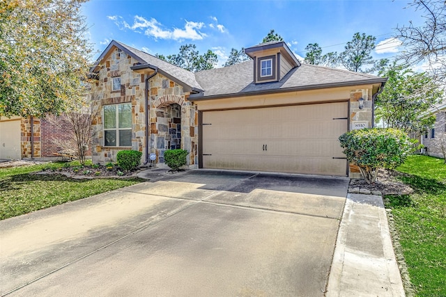 view of front facade with stone siding, driveway, an attached garage, and roof with shingles