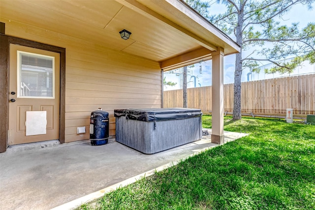 view of patio featuring fence and a hot tub