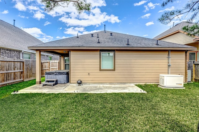 rear view of house with a patio, roof with shingles, a fenced backyard, and a hot tub