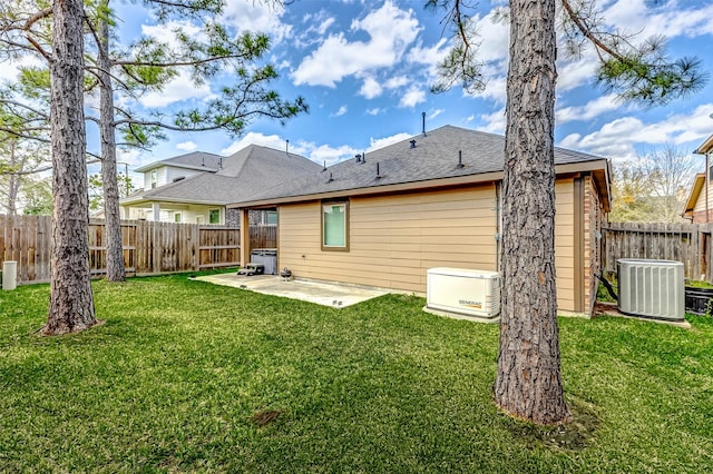 rear view of property with roof with shingles, a yard, a fenced backyard, central AC, and a patio area