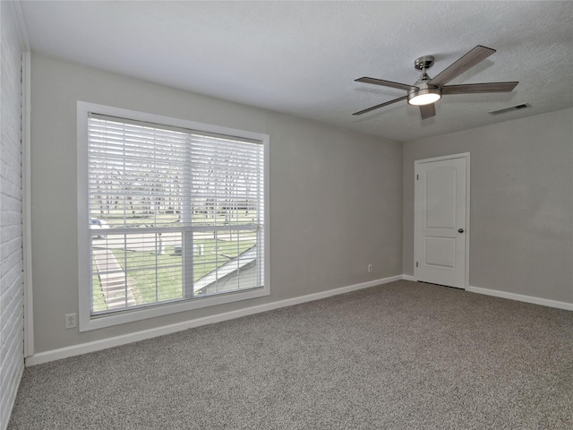 carpeted spare room featuring visible vents, baseboards, and a ceiling fan