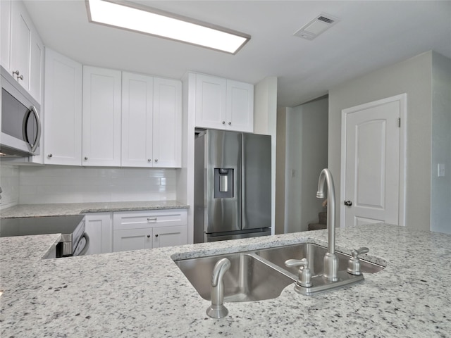 kitchen featuring white cabinetry, visible vents, appliances with stainless steel finishes, and a sink
