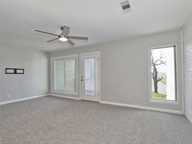 empty room with a healthy amount of sunlight, visible vents, and carpet floors