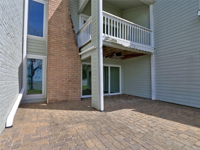 view of patio featuring a ceiling fan and a balcony