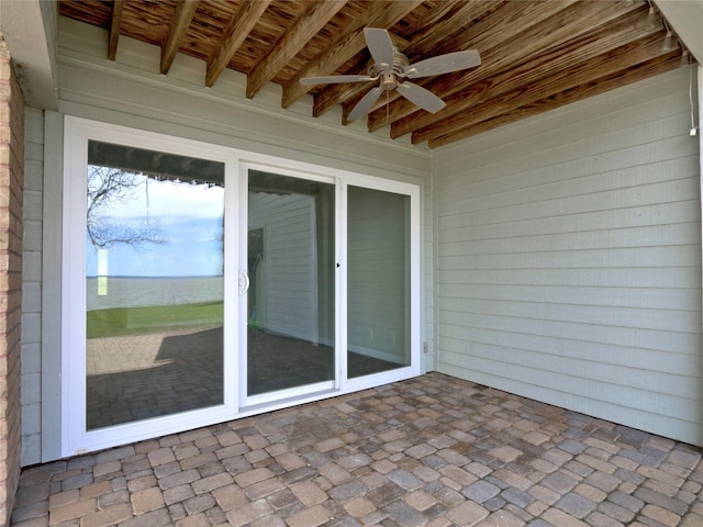 view of patio featuring a water view and a ceiling fan
