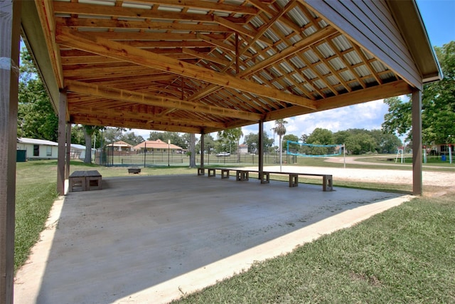 view of property's community with fence, volleyball court, and a lawn