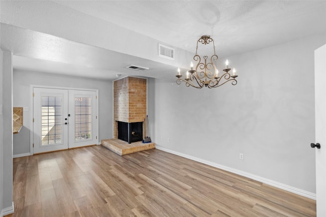 unfurnished living room featuring french doors, baseboards, visible vents, and light wood-style flooring