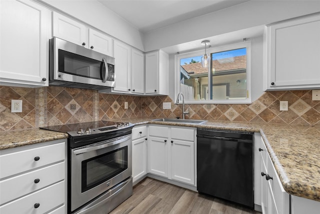 kitchen featuring decorative backsplash, appliances with stainless steel finishes, white cabinetry, and a sink