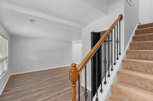 staircase with visible vents, wood finished floors, and baseboards