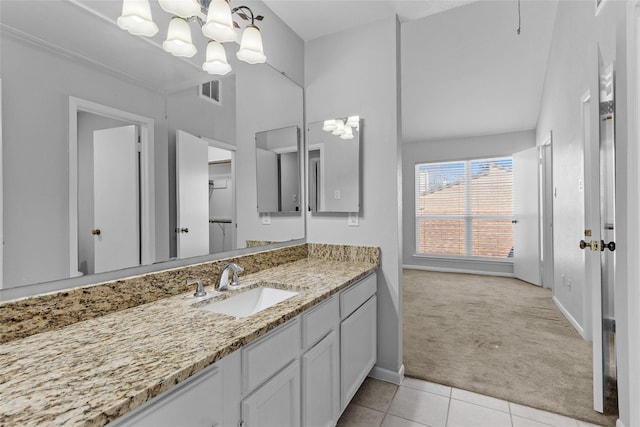 bathroom with vanity, baseboards, visible vents, tile patterned floors, and a notable chandelier