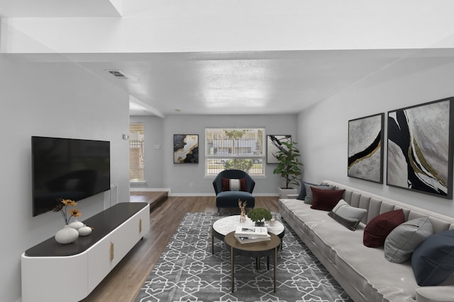 living room featuring visible vents, baseboards, and wood finished floors