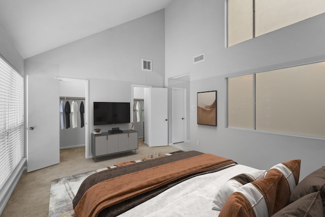 bedroom with vaulted ceiling, a spacious closet, visible vents, and light carpet