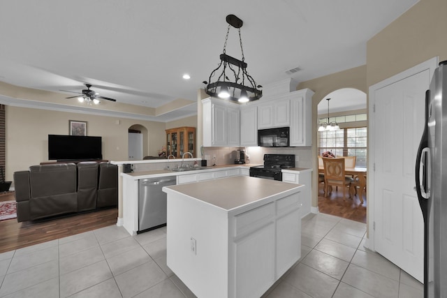 kitchen featuring light tile patterned floors, arched walkways, and black appliances