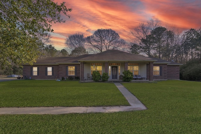 ranch-style house with a lawn and brick siding