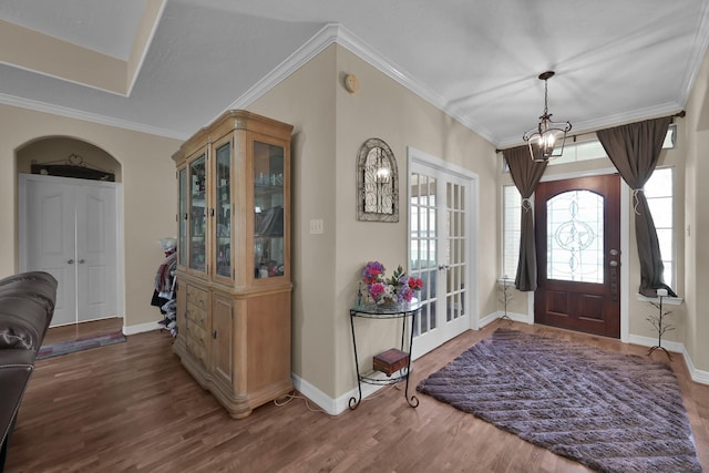 entrance foyer with baseboards, wood finished floors, and ornamental molding