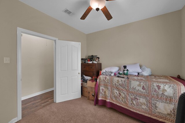 carpeted bedroom with visible vents, lofted ceiling, baseboards, and a ceiling fan