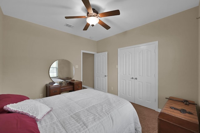 carpeted bedroom featuring a ceiling fan, visible vents, a closet, and baseboards