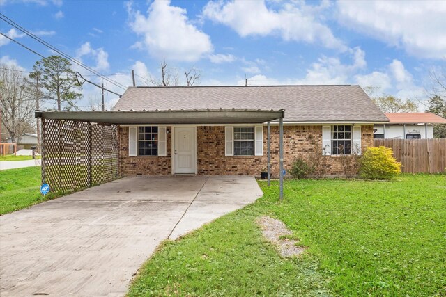 single story home featuring a front yard, fence, driveway, a shingled roof, and brick siding