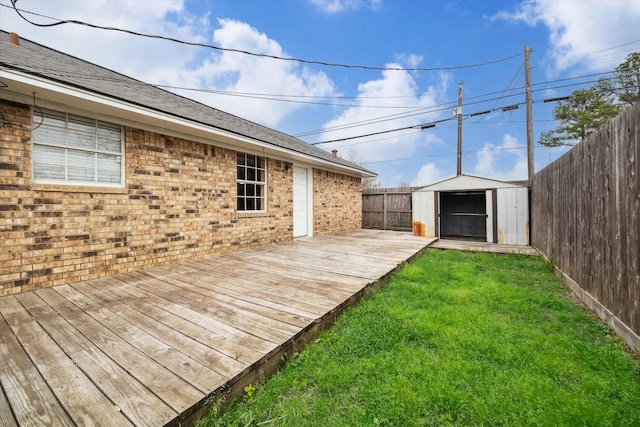 wooden deck featuring an outbuilding, a fenced backyard, a lawn, and a shed