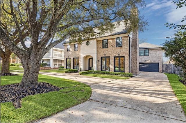 view of front of home featuring fence, concrete driveway, a front yard, a garage, and brick siding