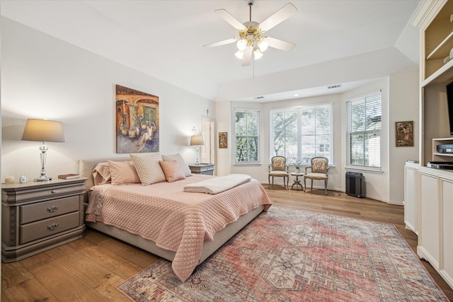 bedroom with vaulted ceiling, wood finished floors, and ceiling fan