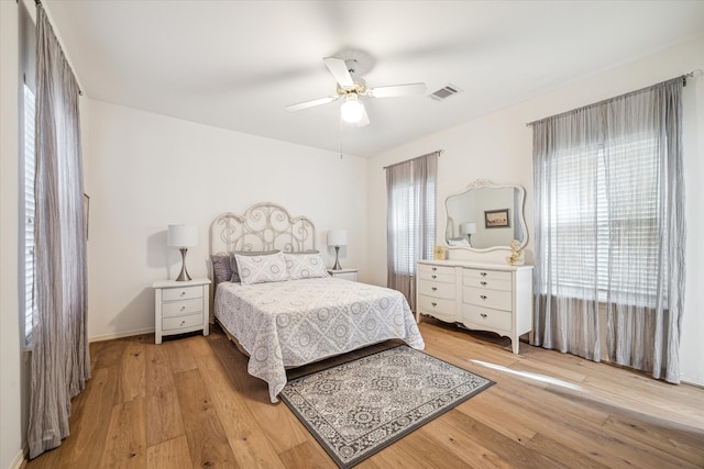 bedroom with visible vents, light wood-style flooring, and a ceiling fan