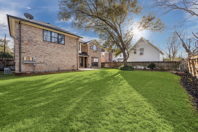 view of yard with central AC and a fenced backyard