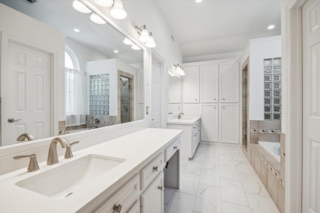 bathroom with two vanities, a stall shower, a sink, a bath, and marble finish floor