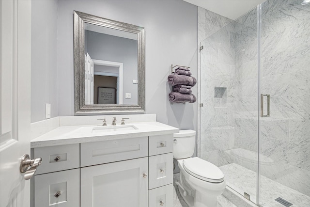 full bathroom with vanity, a shower stall, toilet, and visible vents