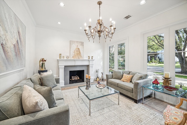 living area featuring visible vents, a fireplace with raised hearth, wood finished floors, and ornamental molding