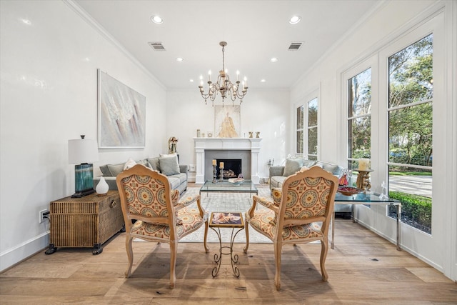 sitting room featuring crown molding, light wood-style flooring, a fireplace, and visible vents