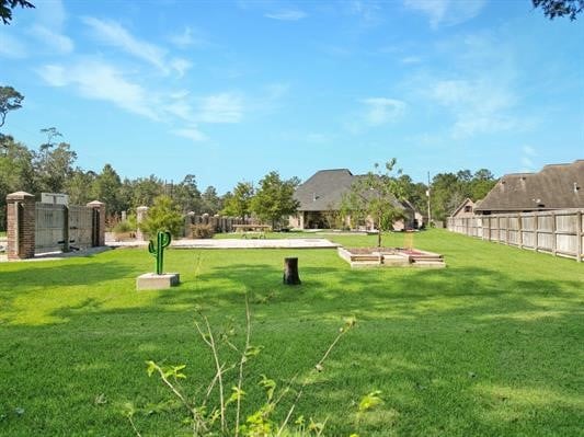 view of home's community with a yard and fence