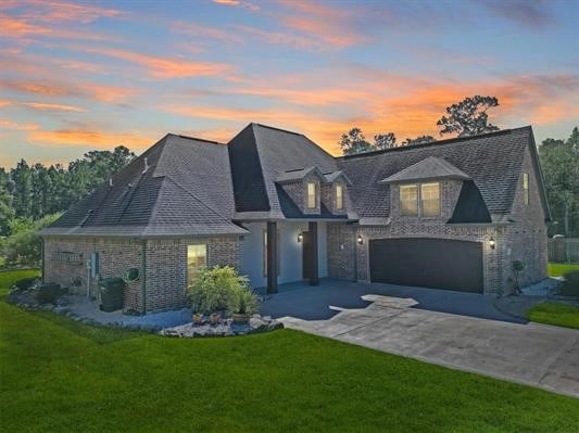 view of front of home with a garage, driveway, and a front yard