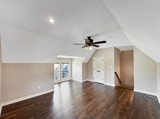 additional living space featuring vaulted ceiling, wood finished floors, baseboards, and ceiling fan