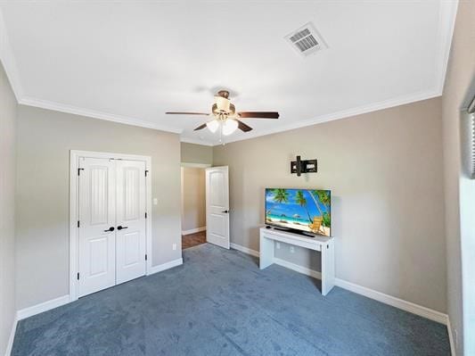 unfurnished bedroom featuring baseboards, visible vents, carpet floors, and ornamental molding