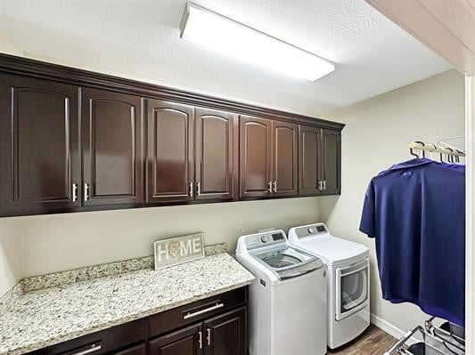 washroom featuring dark wood finished floors, cabinet space, and independent washer and dryer