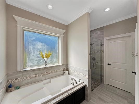 bathroom featuring crown molding, a garden tub, wood finished floors, and a stall shower