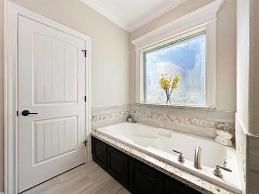 bathroom with crown molding, a garden tub, and wood finished floors