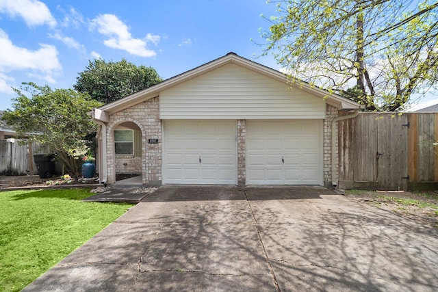 view of front of house featuring a front lawn, brick siding, a garage, and driveway