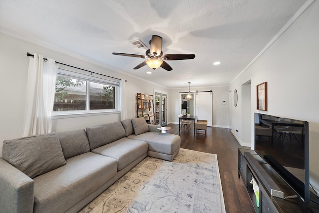 living area featuring visible vents, baseboards, dark wood-type flooring, and crown molding