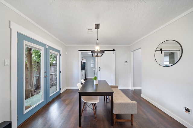 dining area featuring a textured ceiling, dark wood-type flooring, baseboards, and ornamental molding